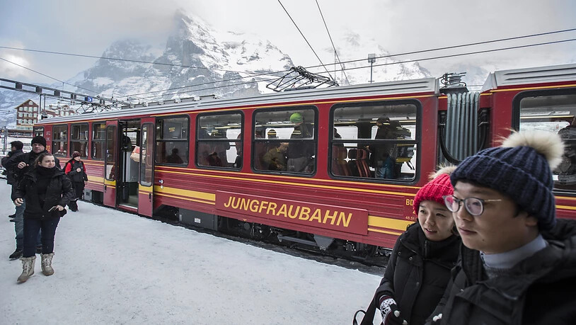 Asiatische Touristen stehen vor einem Zug der Jungfraubahn (Archivbild).