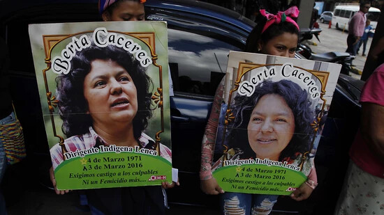 ARCHIV - Zwei Frauen halten bei einem Protest vor dem Sitz der Staatsanwaltschaft Plakaten mit dem Bild der honduranischen Umweltschützerin Berta Caceres. Foto: Fernando Antonio/AP/dpa