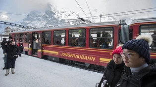 Asiatische Touristen stehen vor einem Zug der Jungfraubahn (Archivbild).