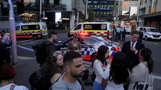 dpatopbilder - Eine Menschenmenge versammelt sich vor dem Westfield Shopping Centre. Medienberichten zufolge wurden in dem Einkaufszentrum in Sydney mehrere Menschen niedergestochen und eine Person von der Polizei erschossen. Foto: Rick Rycroft/AP
