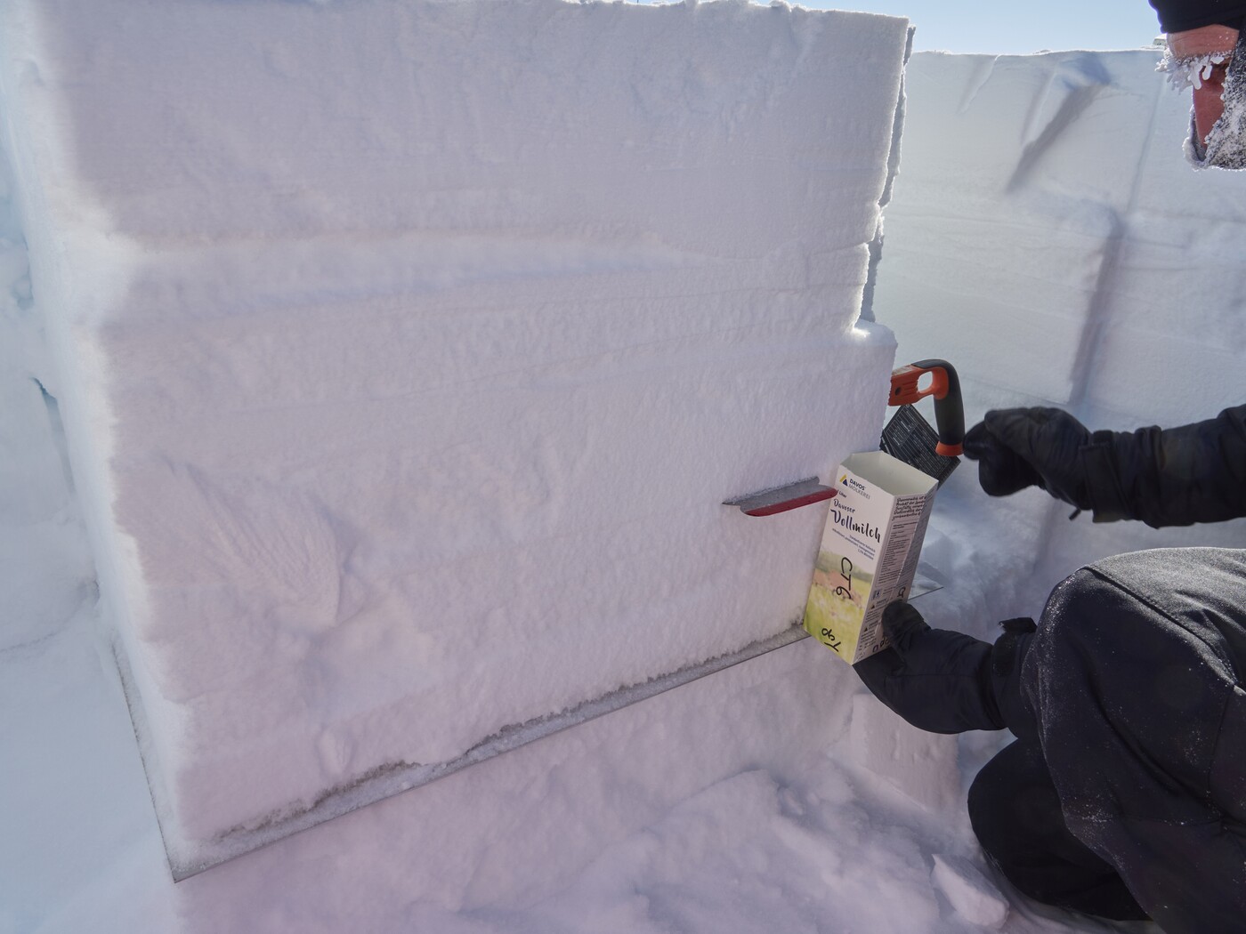 Kurz vor dem endgültigen auf Mass schneiden des Blockes packe ich noch Schneeproben in Davoser Milchpackungen für den Rücktransport. Vor dem Verschicken der Schneeproben werden diese jedoch noch vergossen.