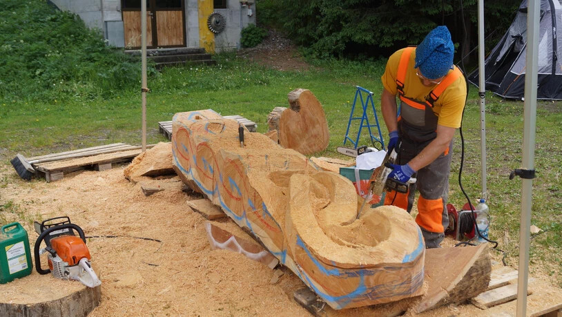 Der Österreicher Klemens Cervenka arbeitet an seiner Holz-Skulptur.