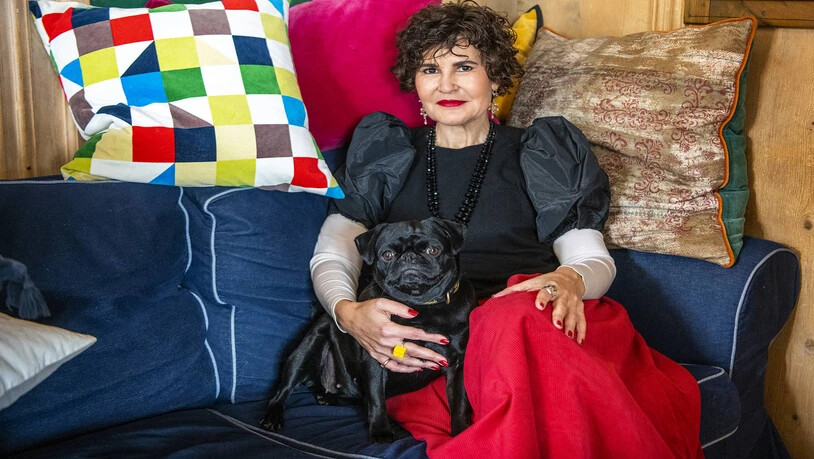 Die Buchautorin Romana Ganzoni macht es sich mit Hund Lulu auf dem Sofa gemütlich.