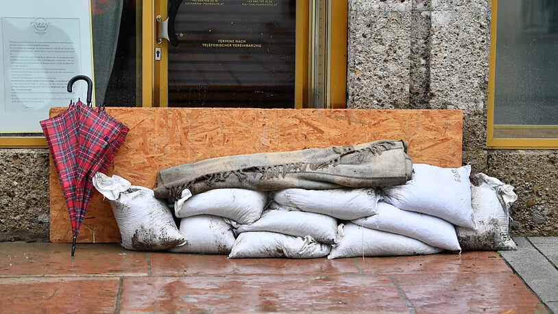 Sandsäcke liegen vor dem Eingang eines Ladens in Hallein. Foto: Barbara Gindl/APA/dpa