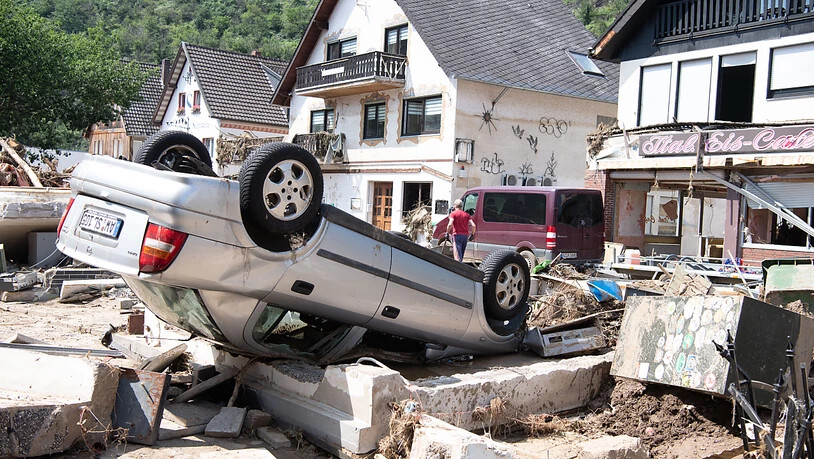 Ein von der Flut mitgerissenes Auto liegt in der Stadtmitte von Altenahr in Rheinland-Pfalz. Foto: Boris Roessler/dpa