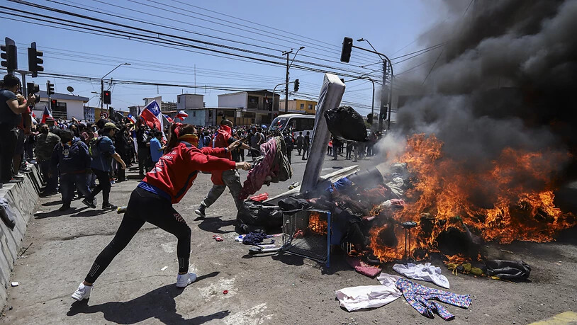 Menschen verbrennen Zelte und Gegenstände venezolanischer und kolumbianischer Migranten während einer Demonstration gegen illegale Einwanderung. Foto: Ignacio Muñoz/AP/dpa