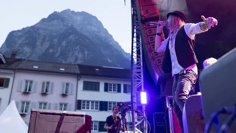 Sänger Nic Maeder performt vor dem Bergpanorama in Glarus.