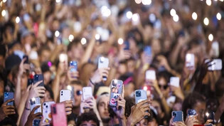 Für viele unverzichtbar: Besucherinnen und Besucher des diesjährigen Paléo Festivals in Nyon zücken während eines Konzerts ihre Smartphones.