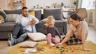 Zusammen die Zeit geniessen: Was eine Familie drinnen machen kann, wenn es draussen stürmt – zum Beispiel einfach mal chillen, spielen und lesen.