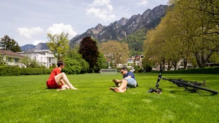 Frühlingsbeginn: Am Wochenende steigen die Temperaturen und die Menschen zieht es in die Natur. Zwei Freunde geniessen die Sonne auf der Turnerwiese in Chur.